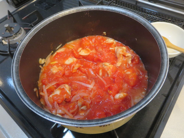 鶏肉と玉ねぎを炒めた中にトマト缶を混ぜる